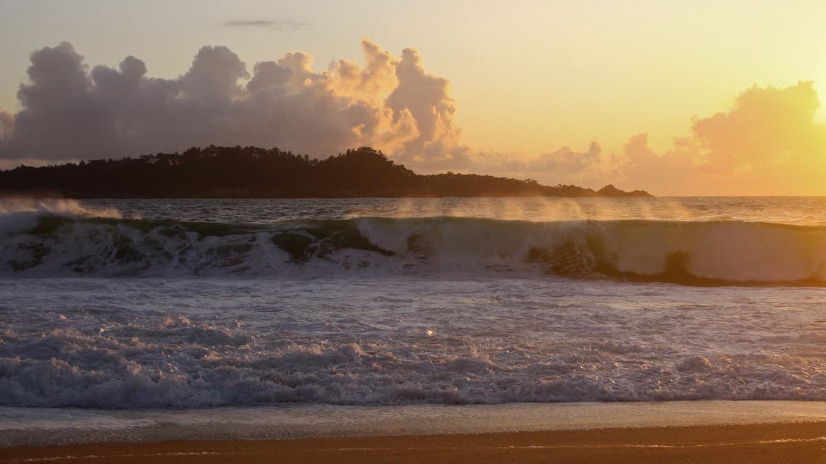 A breaking ocean wave with wind-blown spray off the coast of Carmel Bay.